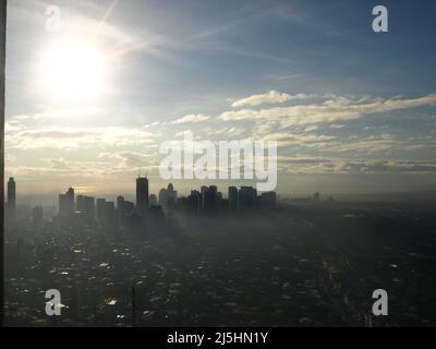 manila Wolkenkratzer Philippinen Wolkenkratzer Gebäude mit Sonne und nebligen Wolken Stockfoto