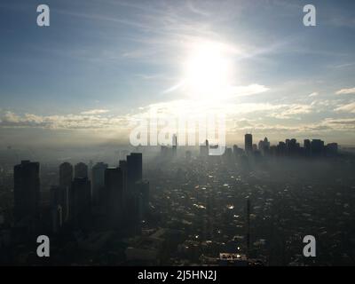 manila Wolkenkratzer Philippinen Wolkenkratzer Gebäude mit Sonne und nebligen Wolken Stockfoto