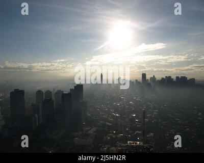 manila Wolkenkratzer Philippinen Wolkenkratzer Gebäude mit Sonne und nebligen Wolken Stockfoto