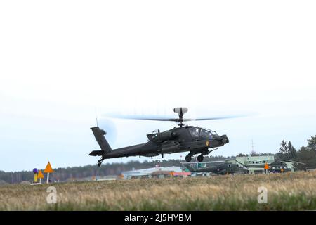 Ein Angriffshubschrauber AH-64E Apache, der der 1. Air Cavalry Brigade, 1. Cavalry Division, zugewiesen wurde, hebt an einem Aufwärts-Aufrüster- und Betankungspunkt in Milroslawiec, Polen, am 4. April 2022 ab. (USA Foto der Armee-Nationalgarde von SPC. Hedil Hernández) Stockfoto