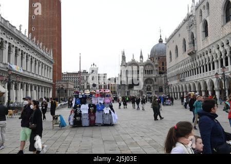 Venedig, Italien. 23. April 2022. T-Shirts und Hüte sind an einem Stand in der Nähe des Markusplatzes erhältlich. Die Kunstbiennale begann heute in der Lagunenstadt. Die Biennale Arte, die alle zwei Jahre stattfindet, gilt weltweit als das älteste und nach der documenta in Kassel das wichtigste internationale Forum für zeitgenössische bildende Kunst. Quelle: Felix Hörhager/dpa/Alamy Live News Stockfoto