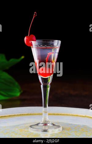 Kirschlikör und Wodka-Cocktail mit Beere auf Holztisch. Stockfoto