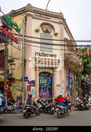 Altes Gebäude an einer belebten Ecke in der Altstadt von Hanoi, Vietnam. Der Name des Geschäfts ist Chuong Vang Stockfoto