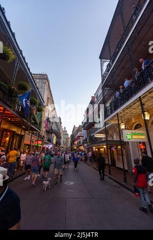 New Orleans, LA - 3. April 2022: Nicht identifizierte Fußgänger auf der Bourbon Street im New Orleans French Quarter Stockfoto