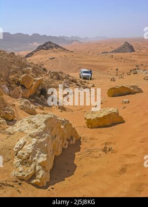 Ein Geländefahrer macht eine Pause, nachdem er den Jebel (Berg) Maleiha, alias Fossil Rock, im Emirat Sharjah in den Vereinigten Arabischen Emiraten befahren hat. Stockfoto