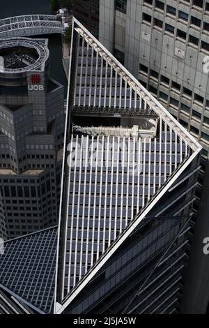 Vertikale Ansicht der Solarpaneele, die auf dem Dach des gewerblichen Wolkenkratzergebäudes installiert sind, um Sonnenenergie zu nutzen. Singapur Stockfoto