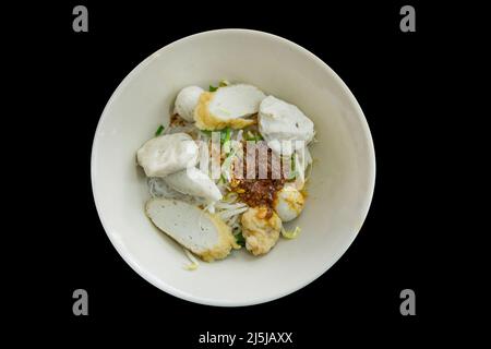 Stempelschnitt von getrockneten Nudeln, Fischbälle auf schwarz isoliert. Stockfoto