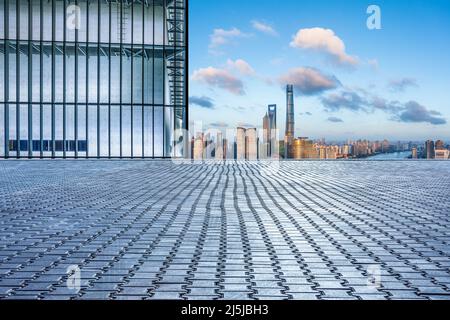 Leerer quadratischer Boden und Skyline der Stadt mit Gebäuden in Shanghai bei Sonnenuntergang, China. Stockfoto