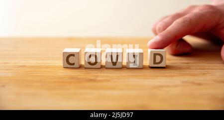 Covid19 Pandemie. Wort kovid auf Holzwürfel mit Finger auf d Buchstabe für Delta-Mutation. Botschaft zum Schutz des Coronavirus, Impfung, Diagnose, Stockfoto