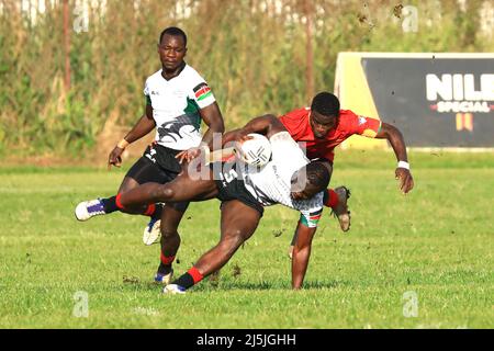 Kampala, Uganda. 23. April 2022. Billy Odhiambo (C) aus Kenia hält sich während eines Spiels zwischen Kenia und Senegal beim African Men's Rugby Sevens Championship-Turnier am Uganda Independence Monument in Kampala, Uganda, am 23. April 2022 am Ball fest. Quelle: Hascharah Nalwadda/Xinhua/Alamy Live News Stockfoto