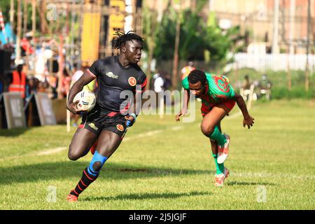 Kampala, Uganda. 23. April 2022. Robert Okeny (L) aus Uganda läuft mit dem Ball während eines Spiels zwischen Uganda und Burundi beim African Men's Rugby Sevens Championship Turnier am Uganda Independence Monument in Kampala, Uganda, am 23. April 2022. Quelle: Hascharah Nalwadda/Xinhua/Alamy Live News Stockfoto