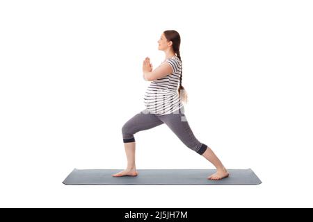 Schwangere beim Yoga Asana Virabhadrasana 1 Stockfoto