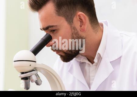 Wissenschaftler verwenden Mikroskop in einem Labor während der Forschungsarbeiten Stockfoto
