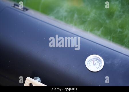 Thermometer auf dem Grill zeigt die Temperatur an. Gerät dämpft. High-Angle-Ansicht. Stockfoto