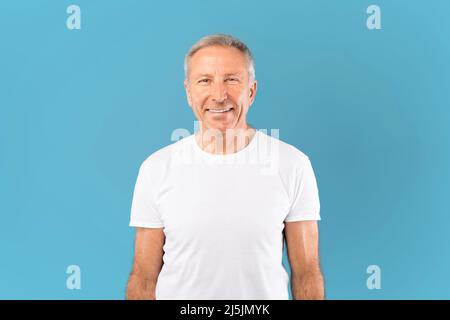 Porträt eines glücklichen, reifen Mannes, der lächelnd im Studio posiert Stockfoto