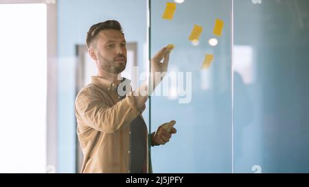 Geschäftsmann Mit Haftnotizen Auf Glas Planung Projekt Im Büro Stockfoto