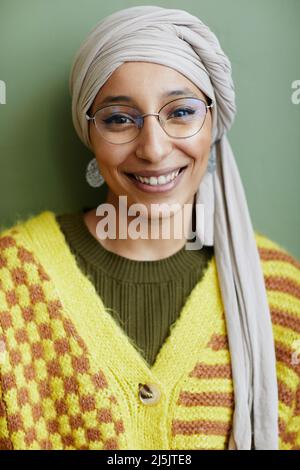 Vertikale Nahaufnahme Porträt einer muslimischen jungen Frau mit Kopftuch und Blick auf die Kamera mit echtem Lächeln Stockfoto