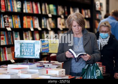 (220424) -- STRATFORD-UPON-AVON, 24. April 2022 (Xinhua) -- Eine Frau liest in einer Buchhandlung in Stratford-upon-Avon, Großbritannien, 23. April 2022. Über 1.000 Menschen versammelten sich in Stratford-upon-Avon, der Heimatstadt von William Shakespeare, um am Samstag den 458.. Geburtstag des britischen Dramatikers zu feiern. (Xinhua/Li Ying) Stockfoto