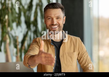 Fröhlicher Geschäftsmann, Der Der Kamera Im Büro Die Hand Für Handshake Anbietet Stockfoto