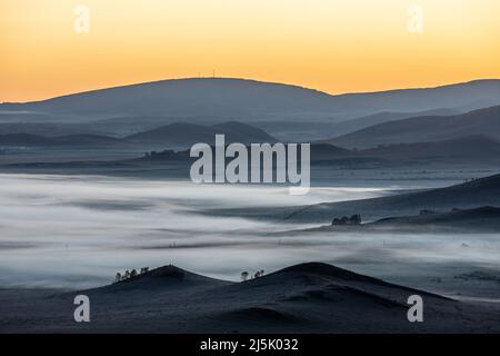 Wunderschöne Naturlandschaft im Ulan Butong Grasland, Innere Mongolei, China. Berge und Wolken Naturlandschaft bei Sonnenaufgang. Stockfoto