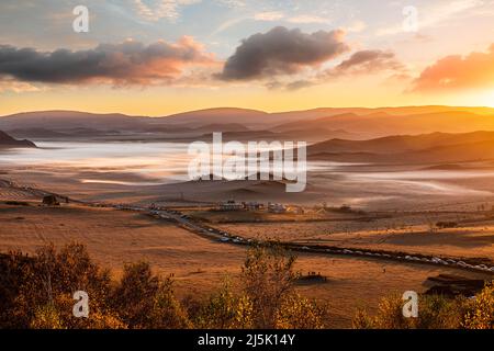 Wunderschöne Naturlandschaft im Ulan Butong Grasland, Innere Mongolei, China. Farbenfrohe Wiesen- und Bergkulisse in der Herbstsaison. Stockfoto