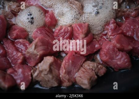 Schweinefleisch oder Rindfleisch werden in einer Pfanne in Öl gebraten Stockfoto