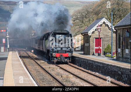 Das Bild zeigt die Southern Railways Battle of Britain Class 4-6-2 Dampflokomotive 34067 Tangmere, die sich dem Bahnhof Garsdale in den Cumbrian Dales nähert Stockfoto