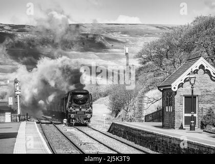 Das Bild zeigt die Southern Railways Battle of Britain Class 4-6-2 Dampflokomotive 34067 Tangmere, die sich dem Bahnhof Garsdale in den Cumbrian Dales nähert Stockfoto