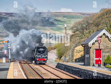 Das Bild zeigt die Southern Railways Battle of Britain Class 4-6-2 Dampflokomotive 34067 Tangmere, die sich dem Bahnhof Garsdale in den Cumbrian Dales nähert Stockfoto