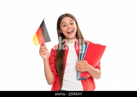 Überraschendes Kind hält deutsche Flagge und Schulkopiebuch für das Studium isoliert auf weißer, deutscher Sprache Stockfoto