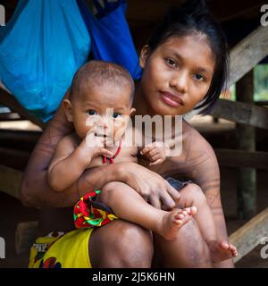 Embera inderin mit Baby im Dorf Embera Puru neben Rio Pequeni, an der Grenze zwischen den Provinzen Panama und Colon, Republik Panama. Stockfoto