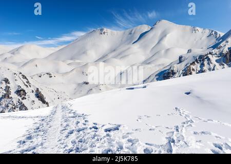 Schneebedeckte Berggipfel in den italienischen Alpen. Gebirgskette des Monte Carega (kleine Dolomiten) im Winter und der Lessinia-Hochebene (Altopiano della Lessinia) Stockfoto