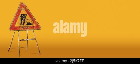 Männer bei der Arbeit oder bei der Arbeit, alte und rostige Straßenschild auf einem gelben und orangefarbenen Hintergrund mit Kopierraum. Italien, Europa. Fotografie. Stockfoto