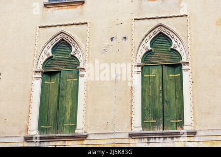 Nahaufnahme von zwei antiken Fenstern mit Bogen im venezianischen gotischen Stil, kleine Stadt Oderzo, Provinz Treviso, Venetien, Italien, Europa. Stockfoto