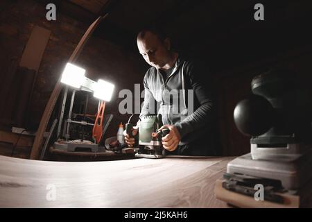 Zimmermann mit elektrischer Handfräsmaschine bei der Arbeit Stockfoto