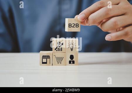 Von Hand Holzwürfel mit B2B Business to Business Icons und Symbolen auf den Tisch legen und Platz kopieren. Stockfoto