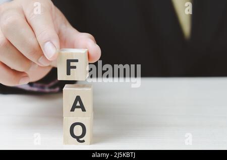 Holzwürfel mit häufig gestellten Fragen von Hand auf Tisch und Platz kopieren.Geschäftskonzepte. Stockfoto