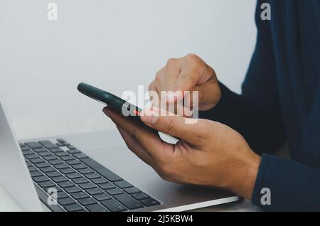Der Geschäftsmann arbeitet im Finanzinvestitionsbüro und analysiert Informationen und kommuniziert mit dem Mobile- und Computer-Concept-Business. Stockfoto