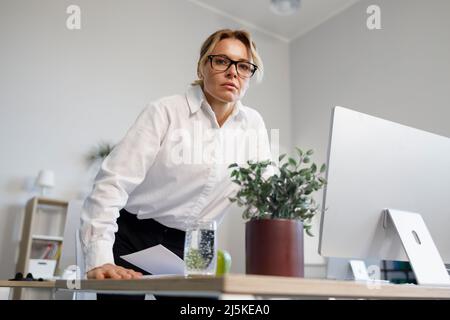 Unzufriedene, seriöse Geschäftsfrau mittleren Alters im Büro, die wütend auf die Kamera schaut Stockfoto