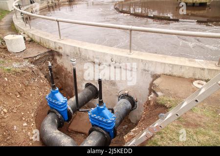 Absperrschieber und Not-Bypass-Ventil vor einem Belüftungstank in einer Kläranlage Stockfoto