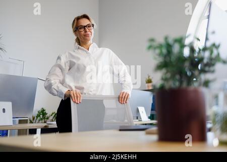 Porträt einer schönen reifen Geschäftsfrau, die im Büro steht Stockfoto