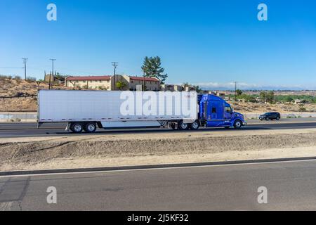 Apple Valley, CA, USA – 20. April 2022: Ein Sattelschlepper fährt auf dem State Highway 18 in Apple Valley, Kalifornien. Stockfoto