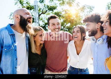 Gruppe lächelnder junger Freunde, die gemeinsam im Freien Spaß haben Stockfoto