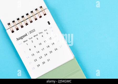 Der August-Kalender 2022 auf blauem Hintergrund. Stockfoto