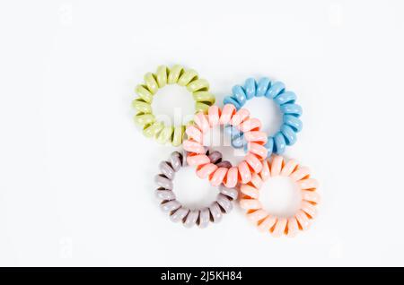 Gruppe von bunten Spiral Gummibänder. Elastische Haarbänder in lebendigen Farben auf weißem Hintergrund. Stockfoto
