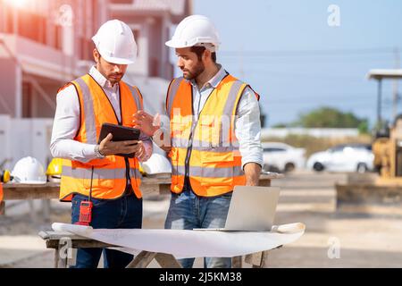 Ingenieur und Architekt diskutieren Bauplan auf Baustelle, Gruppe von Bauherren mit Gespräch über Bauplan, Geschäft, Gebäude, Industrie Stockfoto