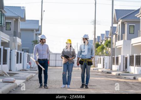 Ingenieur und Architekt diskutieren Bauplan auf Baustelle, Gruppe von Bauherren mit Gespräch über Bauplan, Geschäft, Gebäude, Industrie Stockfoto