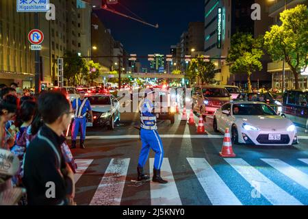 Osaka, Japan - 25. Juli 2015: Verkehrskontrollbeamter leitet Fußgänger nach dem Tenjin Matiri-Sommerfest über die Kreuzung Stockfoto