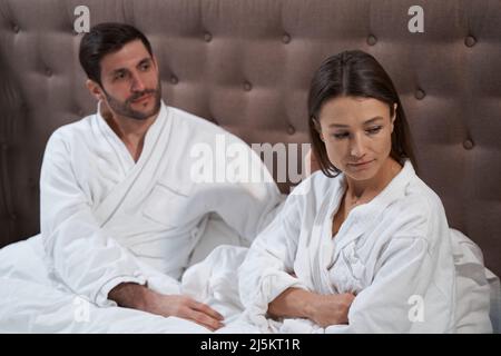 Frau beleidigte ihren Partner im Hotelbett Stockfoto