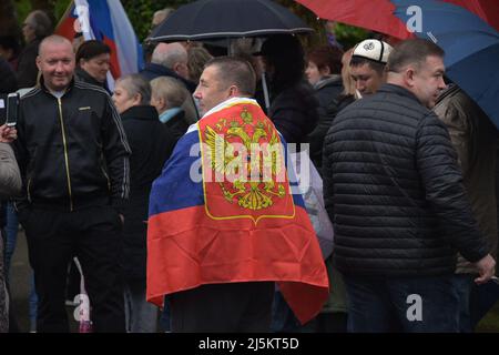 Lahr, Deutschland. 24. April 2022. Vor dem Beginn einer prorussischen Autokolonne durch Lahr, wo Tausende von Rückkehrern aus der ehemaligen Sowjetunion leben, treffen sich Menschen. Etwa 100 Menschen versammelten sich am Bahnhof in der Stadt Ortenau, so ein Polizeisprecher. Nach Angaben der Organisatoren richtete sich der Protest gegen die "Diskriminierung gegen russische Deutsche, für den Frieden, gegen den Krieg". Quelle: Maren Richter/Thomas Reichelt/dpa/Alamy Live News Stockfoto